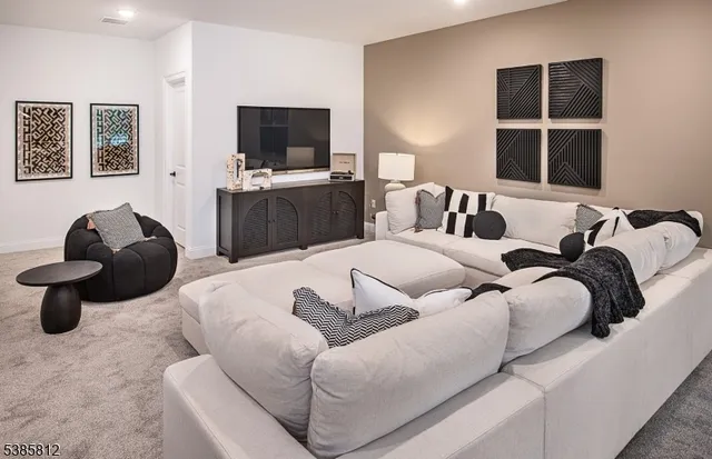 a living room with furniture a flat screen tv and a window