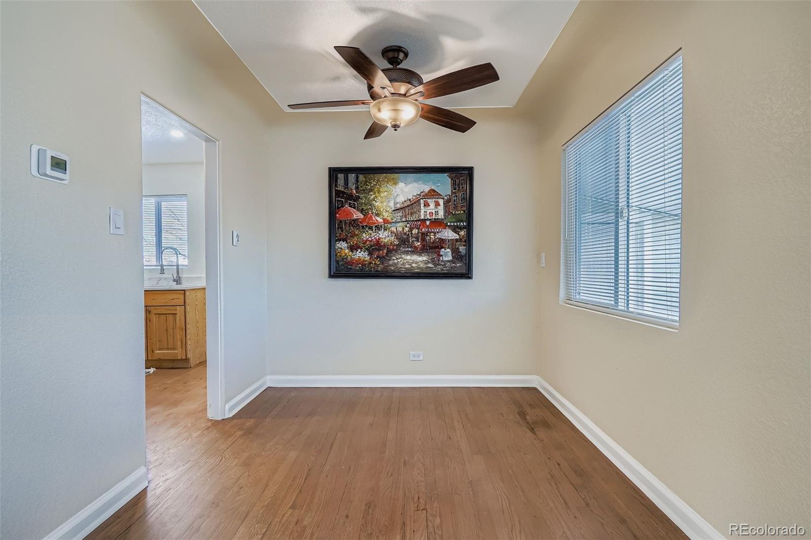 680 Irving Street Denver, CO 80204 - Photo 11 of 33 an empty room with wooden floor and ceiling fan