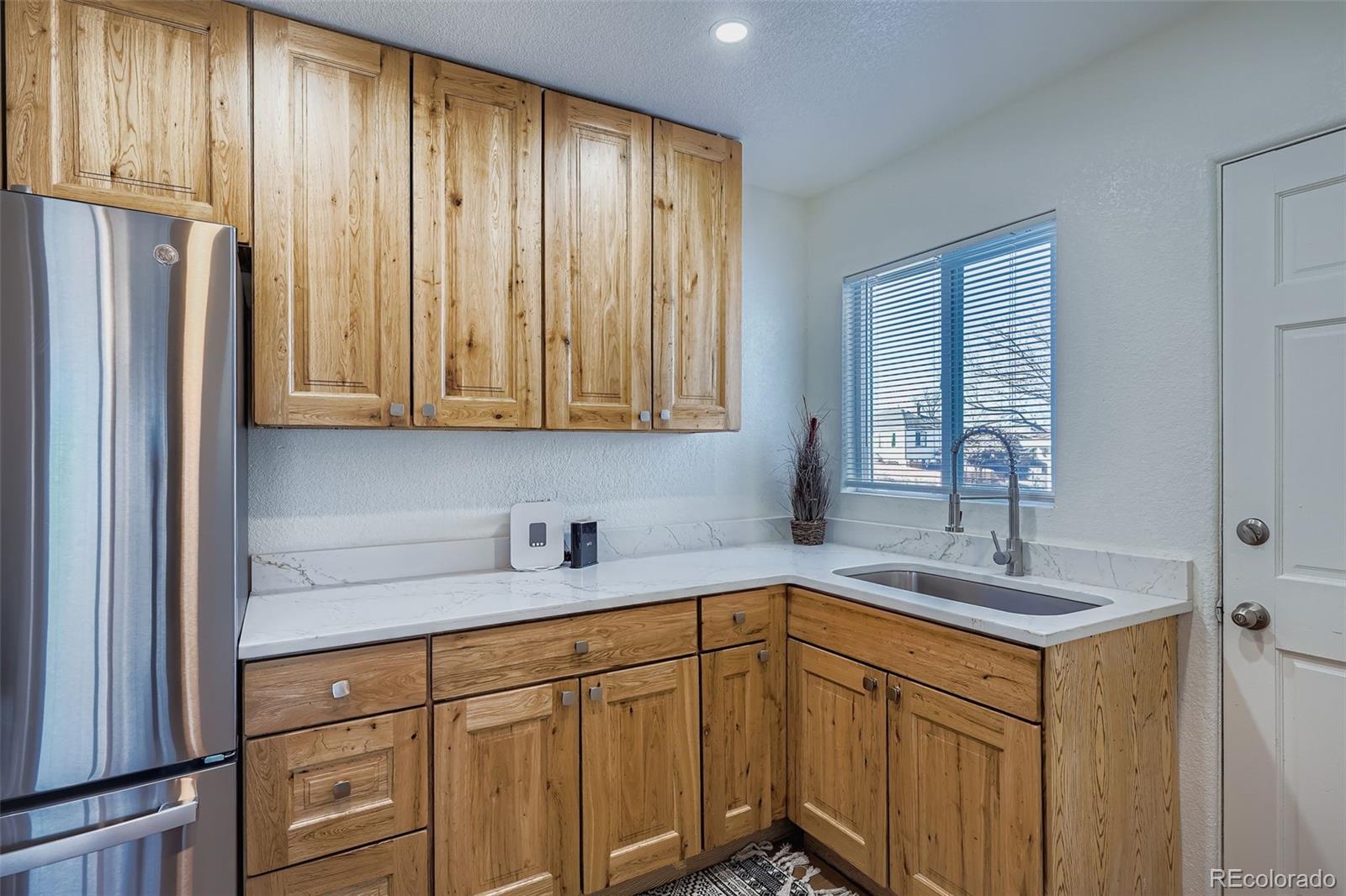 680 Irving Street Denver, CO 80204 - Photo 14 of 33 a kitchen with stainless steel appliances granite countertop a sink cabinets and a refrigerator