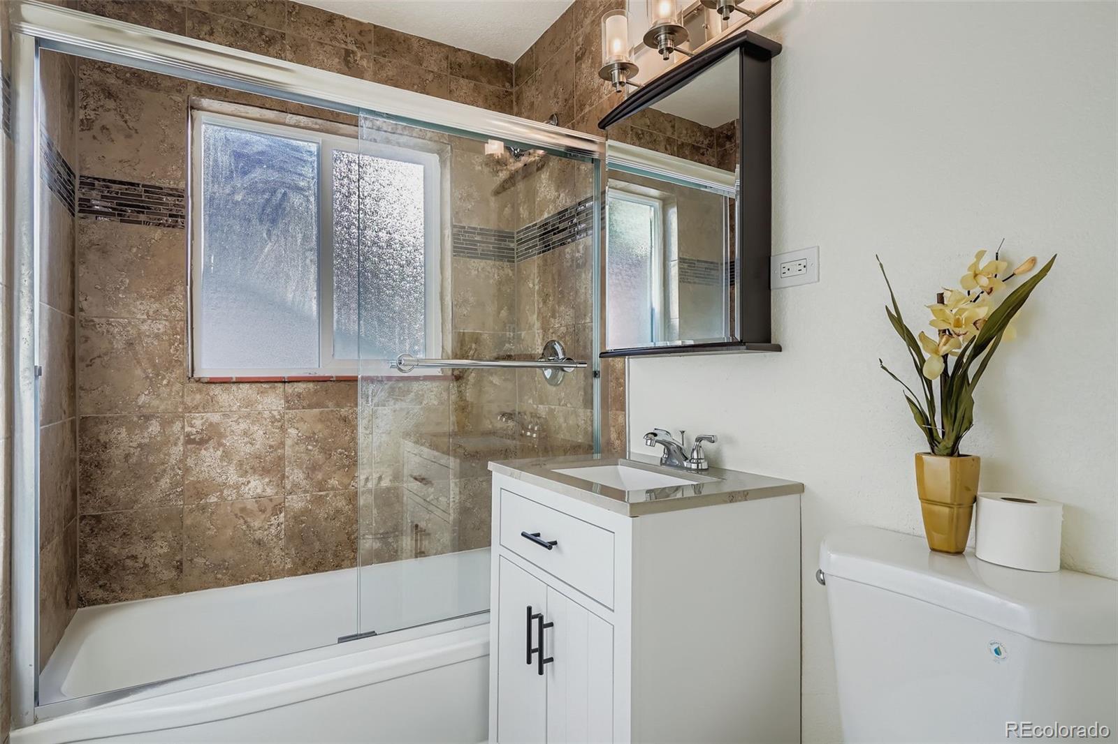 680 Irving Street Denver, CO 80204 - Photo 18 of 33 a bathroom with a granite countertop sink a mirror and shower