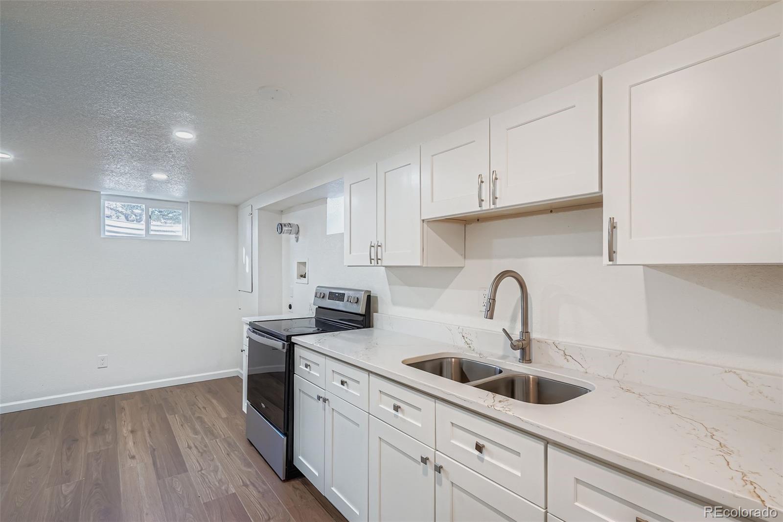 680 Irving Street Denver, CO 80204 - Photo 24 of 33 a kitchen with stainless steel appliances a sink a stove top oven a counter space and cabinets