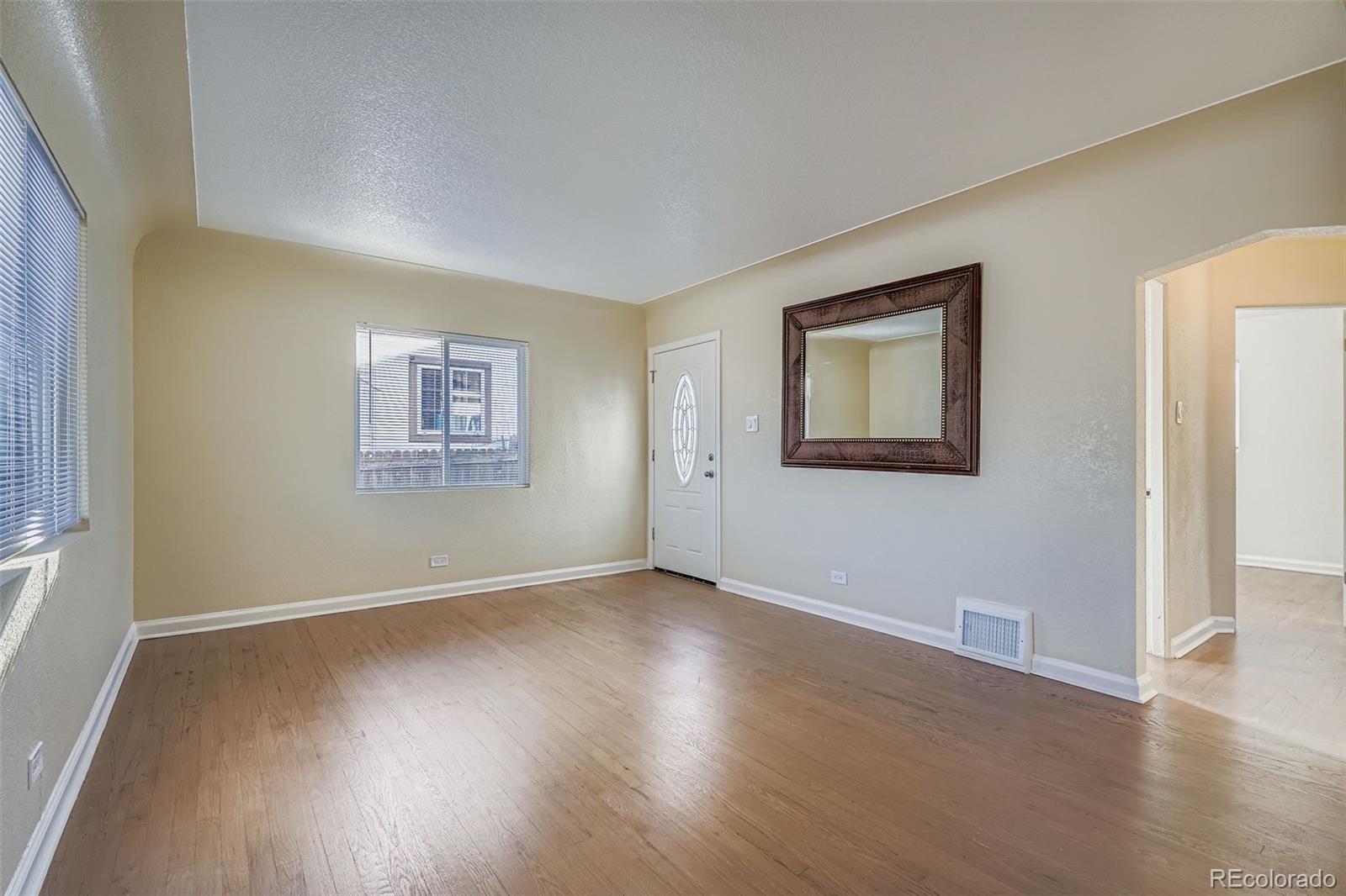 680 Irving Street Denver, CO 80204 - Photo 6 of 33 a view of an empty room with wooden floor and a window