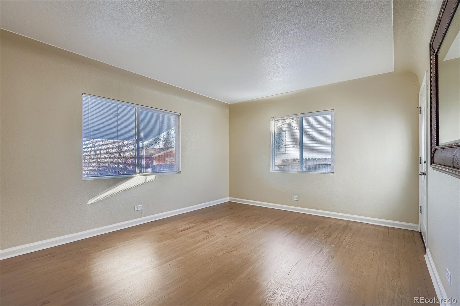 680 Irving Street Denver, CO 80204 - Photo 7 of 33 an empty room with wooden floor and windows