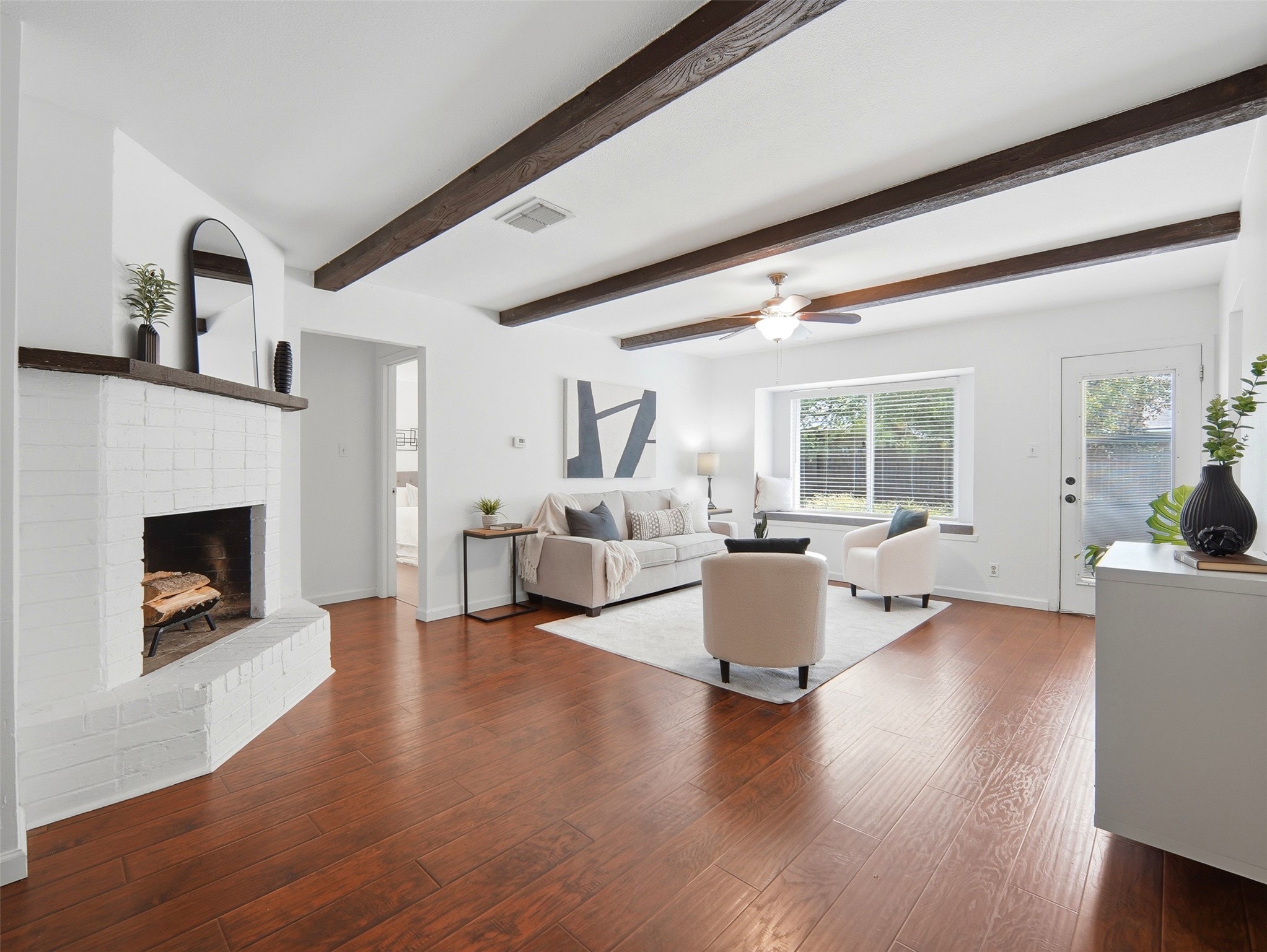 7001 Windrift Way Austin, TX 78745 - Photo 3 of 17 Exposed beams and a white-painted brick fireplace define this inviting living area.