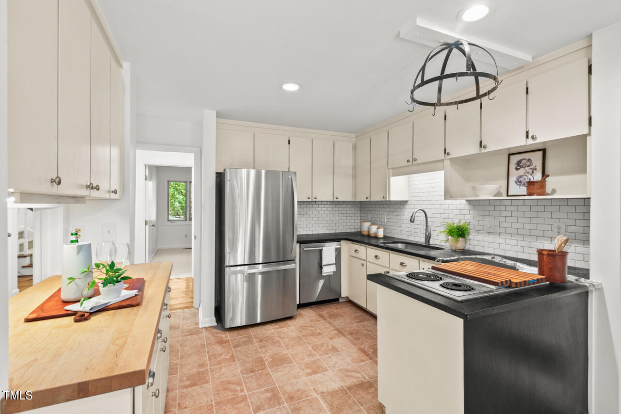 50 Stoneridge Road Durham, NC 27705 - Photo 15 of 40 a kitchen with stainless steel appliances granite countertop a refrigerator a stove a sink and white cabinets