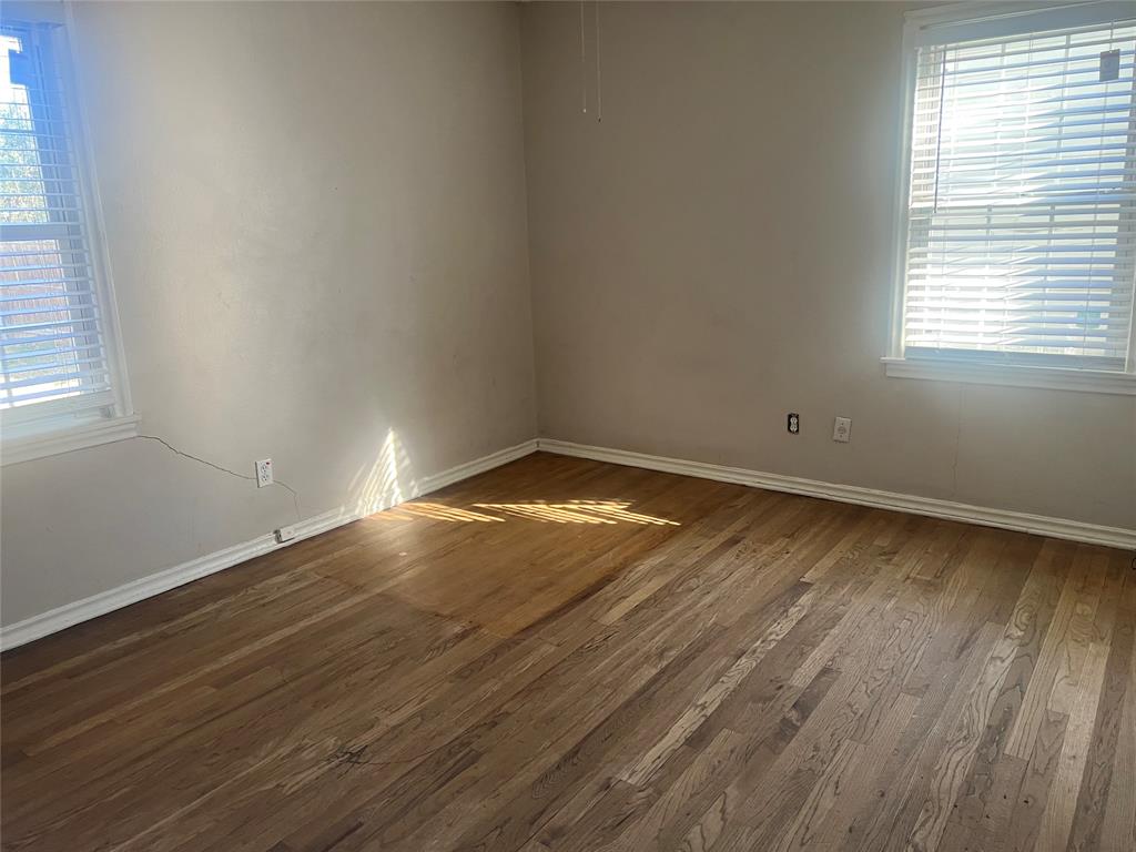 1721 Jocyle Street Arlington, TX 76010 - Photo 17 of 30 an empty room with wooden floor and windows in a room