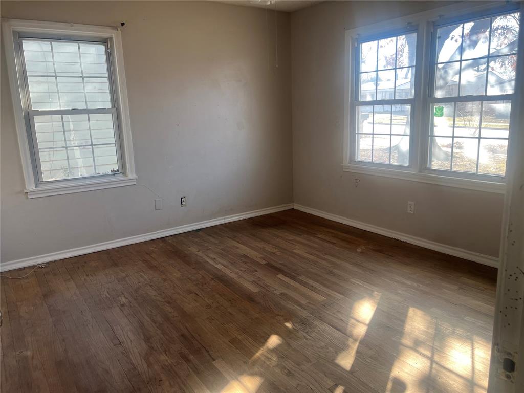 1721 Jocyle Street Arlington, TX 76010 - Photo 18 of 30 an empty room with wooden floor and windows