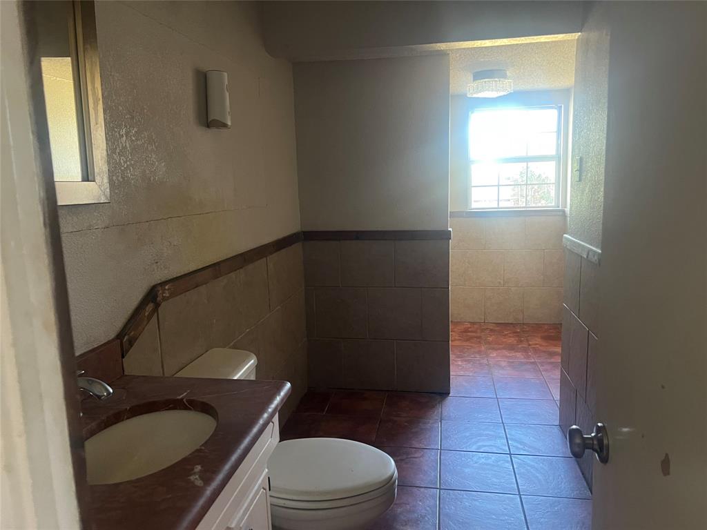 1721 Jocyle Street Arlington, TX 76010 - Photo 20 of 30 a bathroom with a granite countertop toilet and a sink