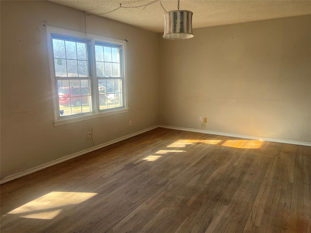 1721 Jocyle Street Arlington, TX 76010 - Photo 5 of 30 an empty room with wooden floor and windows