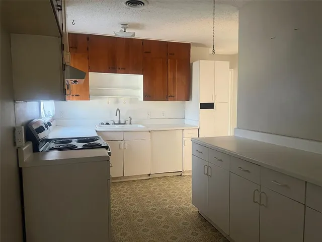 a kitchen with a sink stove and cabinets