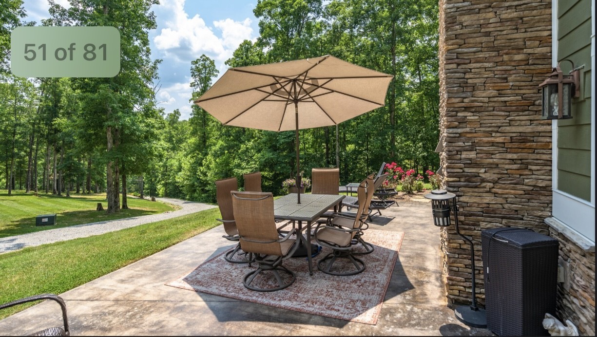 5560 Pinewood Road Franklin, TN 37064 - Photo 7 of 43 a view of a backyard with table and chairs under an umbrella