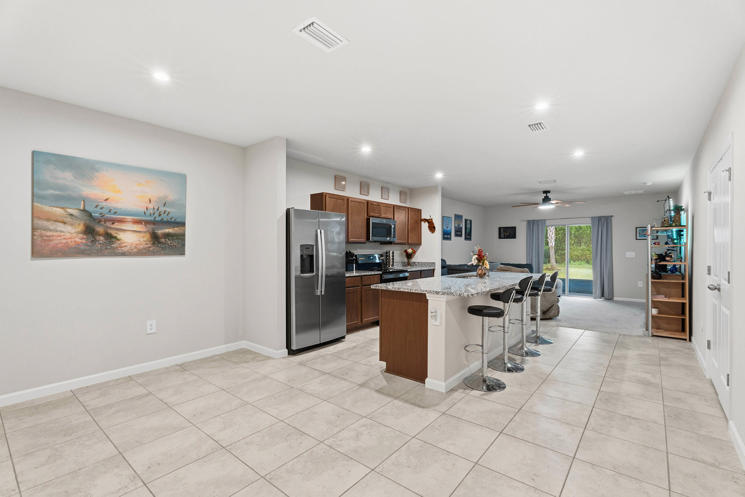 271 Raspberry Road Fort Pierce, FL 34981 - Photo 6 of 42 a kitchen with stainless steel appliances kitchen island granite countertop a refrigerator a sink a counter top space and cabinets