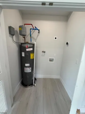 a view of water heater room with wooden floor