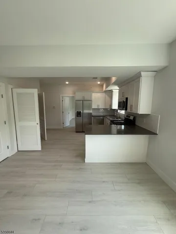 a view of kitchen with stainless steel appliances kitchen island sink and refrigerator