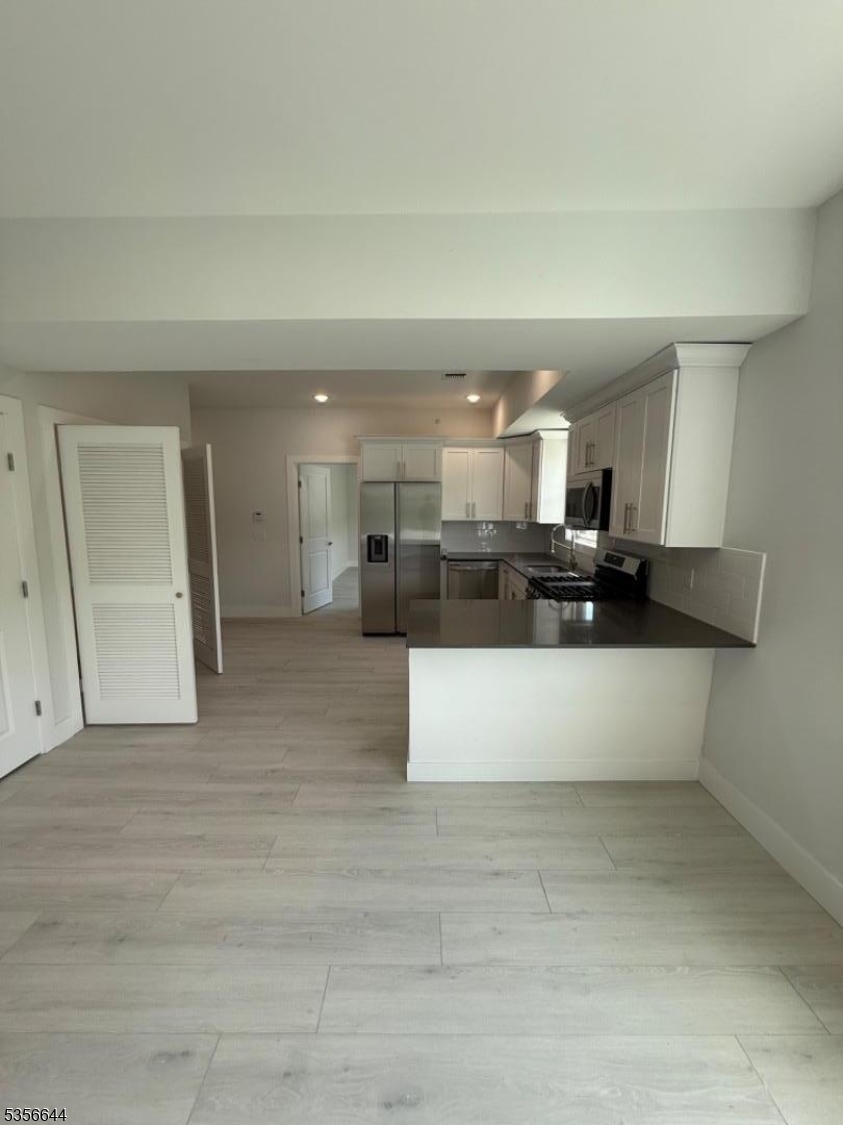 261 Marshall Street, Unit 507 Paterson, NJ 07503 - Photo 4 of 14 a view of kitchen with stainless steel appliances kitchen island sink and refrigerator