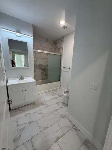 a bathroom with a sink a toilet and mirror