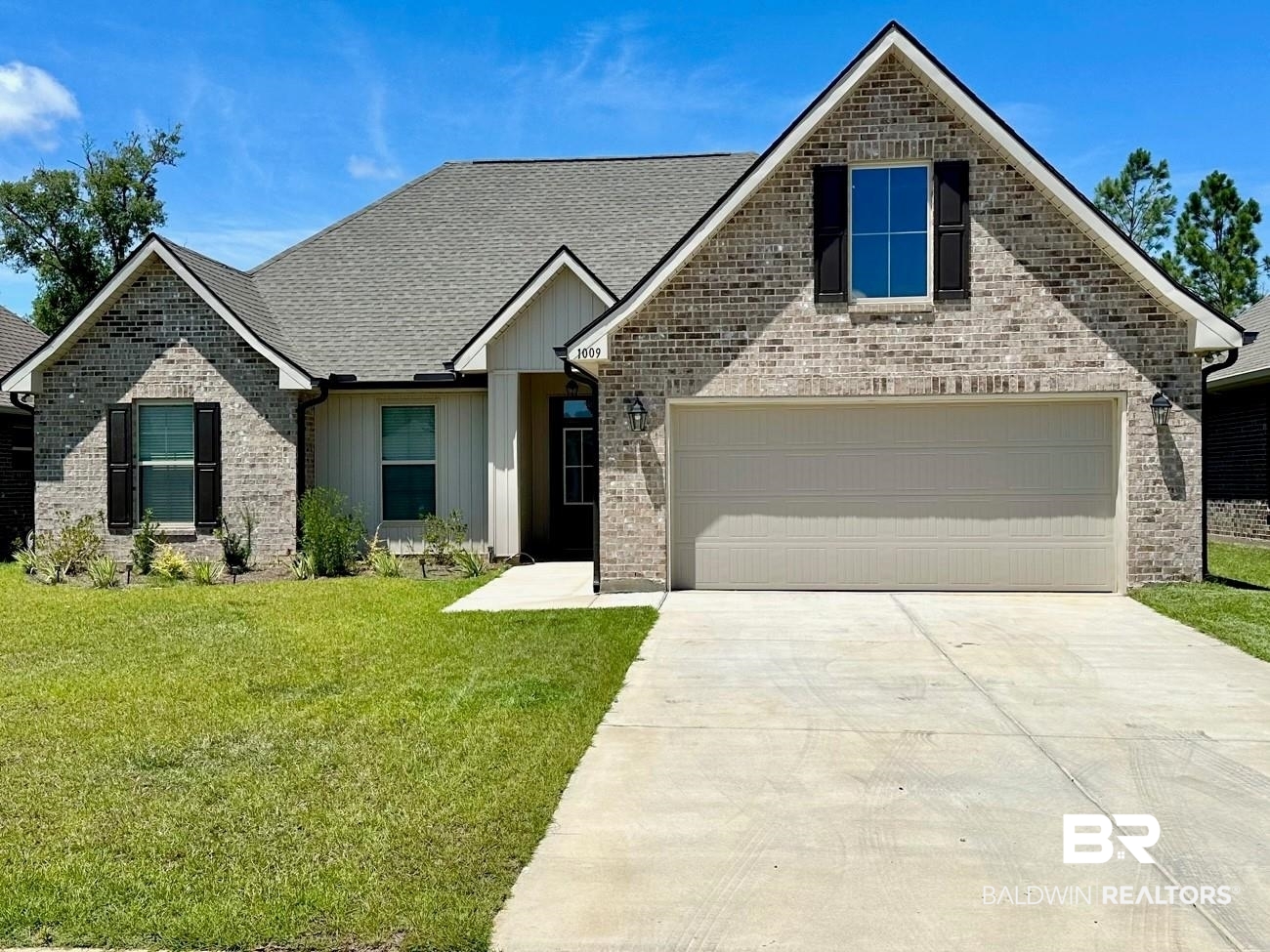 View of front facade featuring a front lawn and a garage