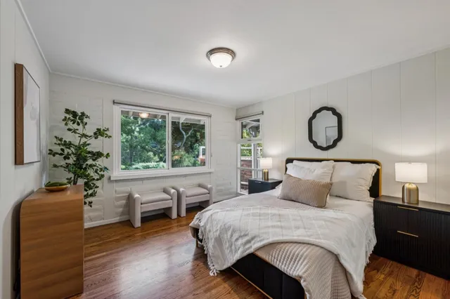a spacious bedroom with a bed a couch and large window