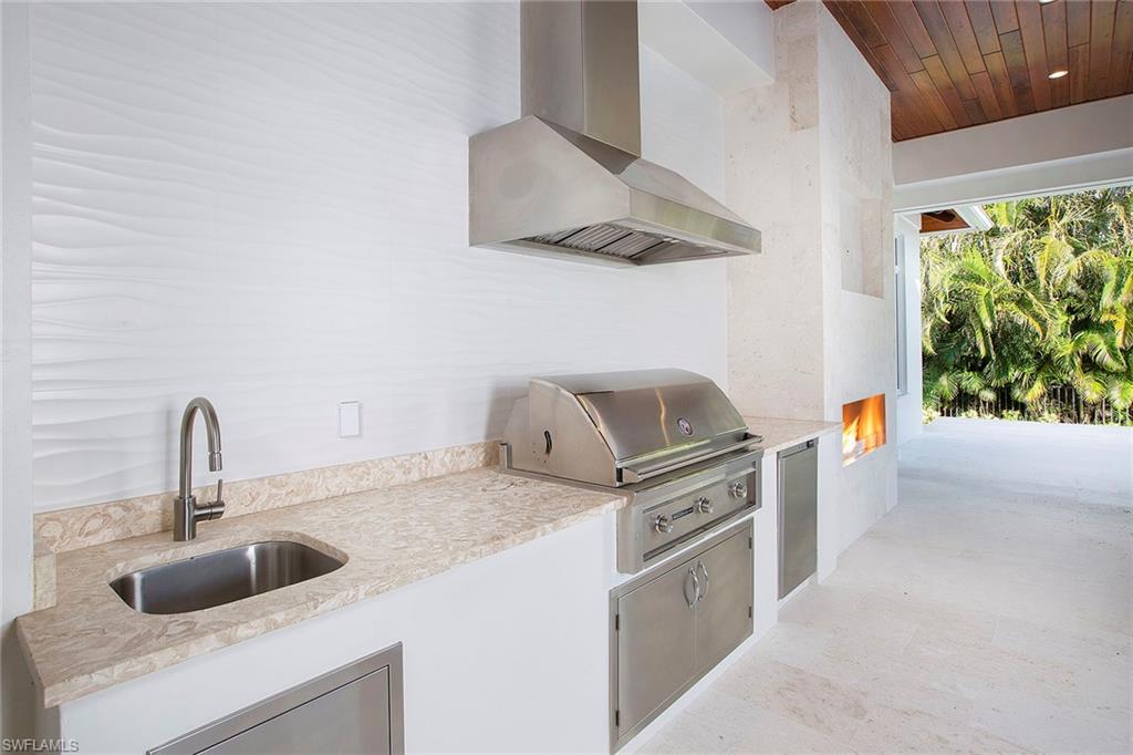 3020 Crayton Road Naples, FL 34103 - Photo 3 of 6 a kitchen with stainless steel appliances granite countertop a sink and a stove next to a window