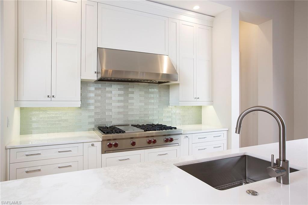 3020 Crayton Road Naples, FL 34103 - Photo 5 of 6 a kitchen with granite countertop a stove a sink and a microwave