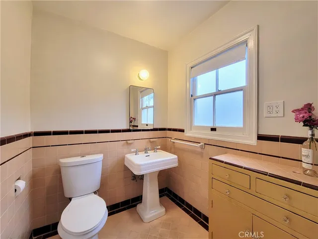 a bathroom with a toilet a sink and a window