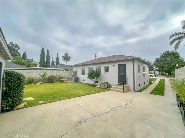 a view of a house with backyard and sitting area