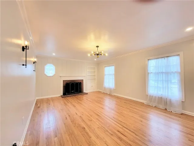 wooden floor fireplace and windows in an empty room