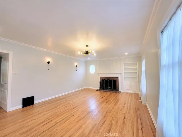 wooden floor fireplace and windows in an empty room
