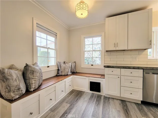 a kitchen with granite countertop white cabinets and window