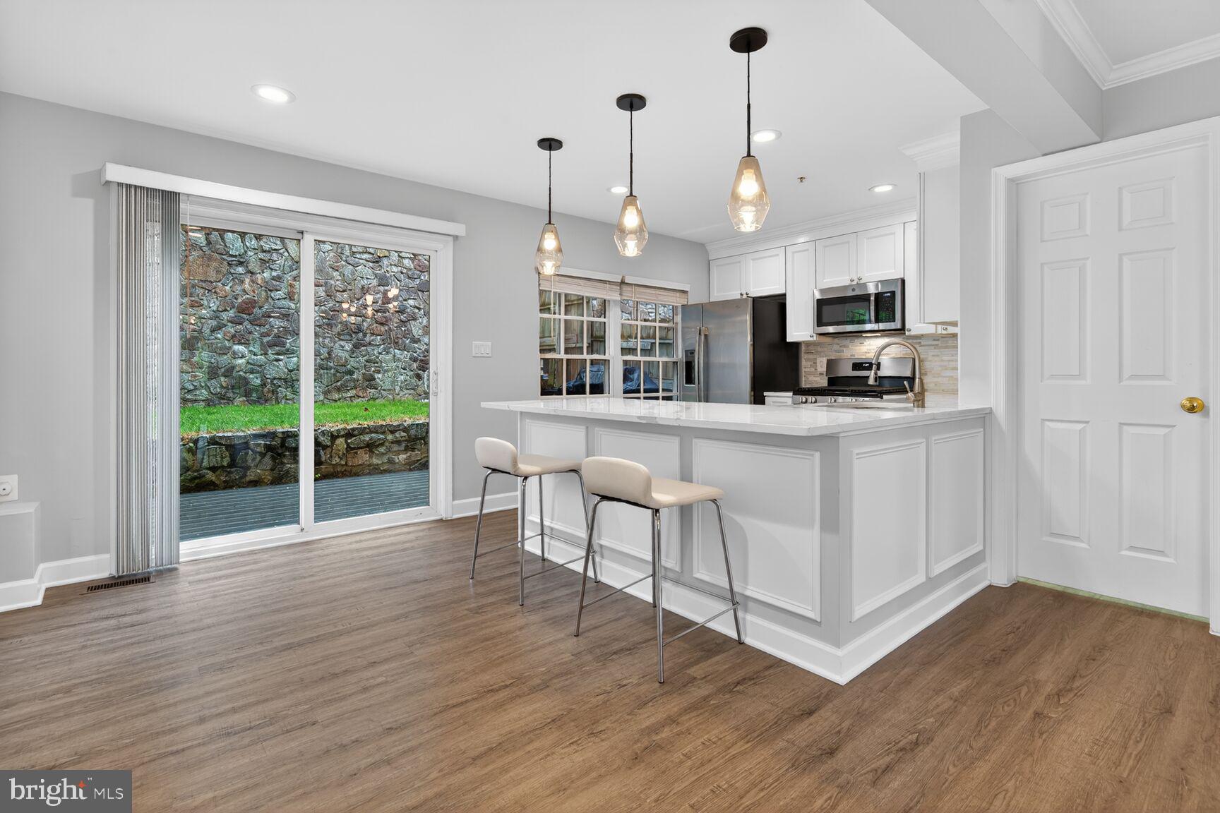 300 Center Lane Occoquan, VA 22125 - Photo 5 of 50 a large kitchen with kitchen island granite countertop a stove a sink a refrigerator and white cabinets with wooden floor