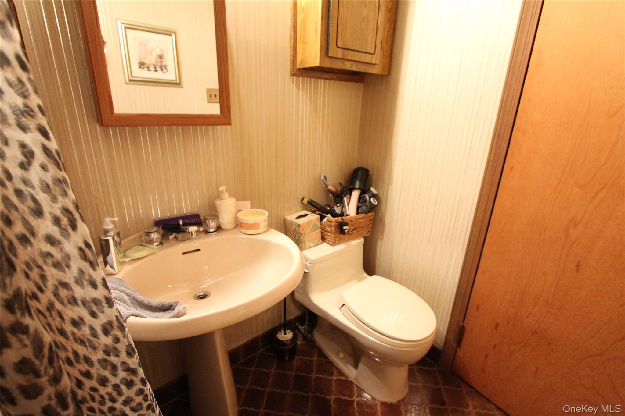 133-28 86th Street Queens, NY 11417 - Photo 14 of 17 a bathroom with a sink and mirror with toilet