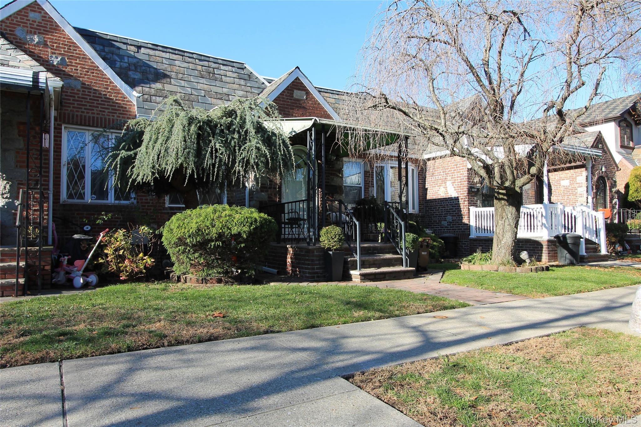 133-28 86th Street Queens, NY 11417 - Photo 2 of 17 a view of a white house with a yard garden and plants