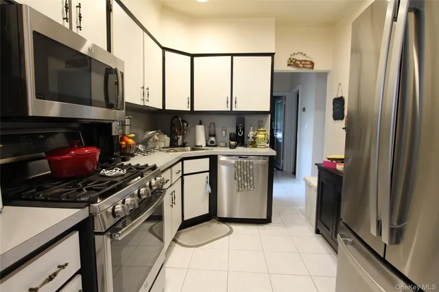 a kitchen with stainless steel appliances granite countertop a refrigerator stove top oven a sink and dishwasher