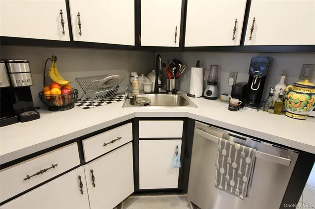 a kitchen with a sink a microwave and cabinets
