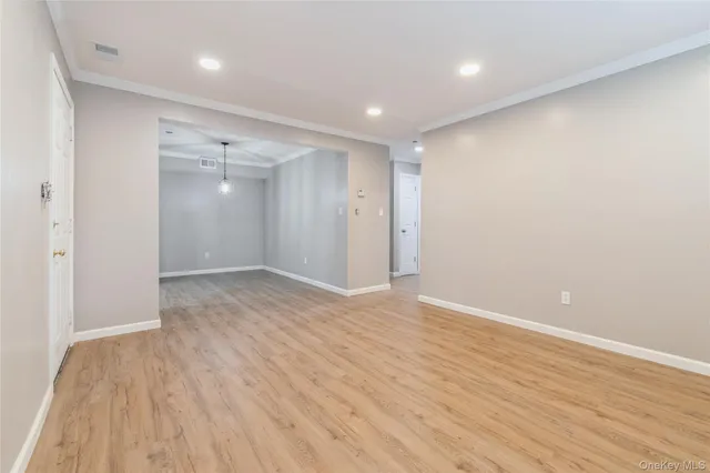 a view of an empty room with wooden floor