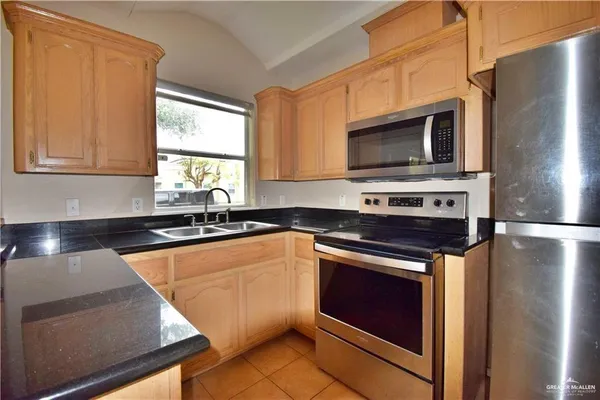 a kitchen with stainless steel appliances a stove microwave and sink
