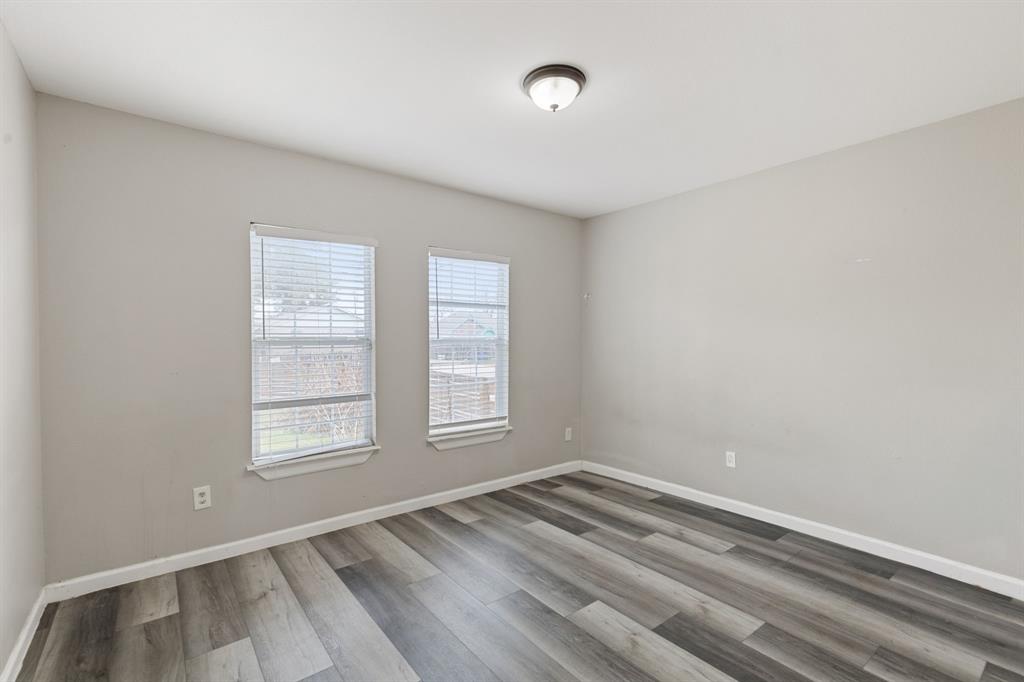 413 East 10th Street Dallas, TX 75203 - Photo 5 of 8 an empty room with wooden floor and windows