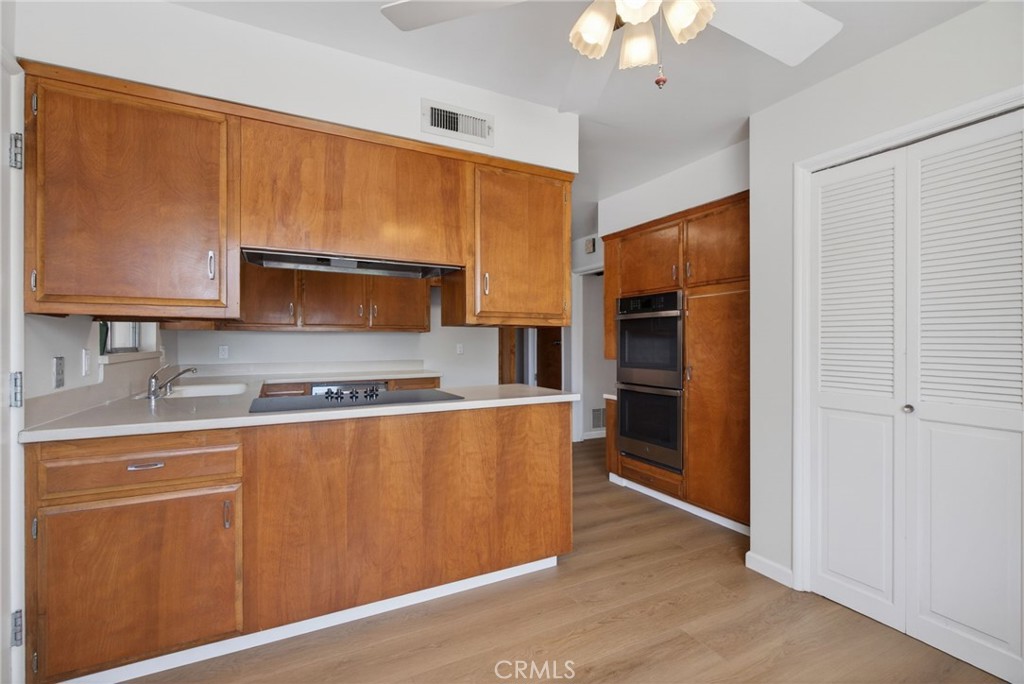 4963 Carlingford Avenue Riverside, CA 92504 - Photo 12 of 33 a kitchen with stainless steel appliances granite countertop a refrigerator a stove and a sink with wooden floor