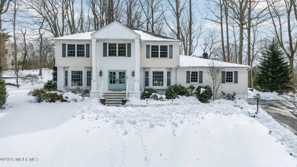 a front view of a house with a yard covered with snow