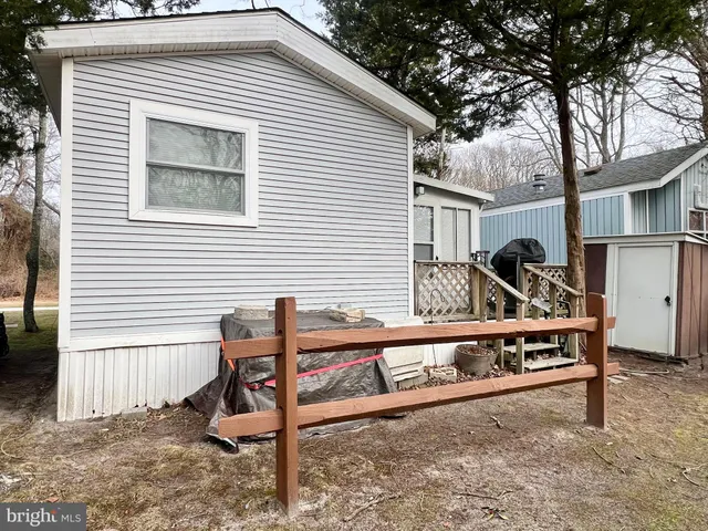 a view of a house with backyard wooden fence and a large tree