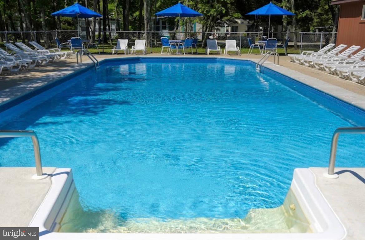 709 Seashore Road, Unit 626 Cape May, NJ 08204 - Photo 24 of 29 a view of swimming pool with chairs and tables under an umbrella