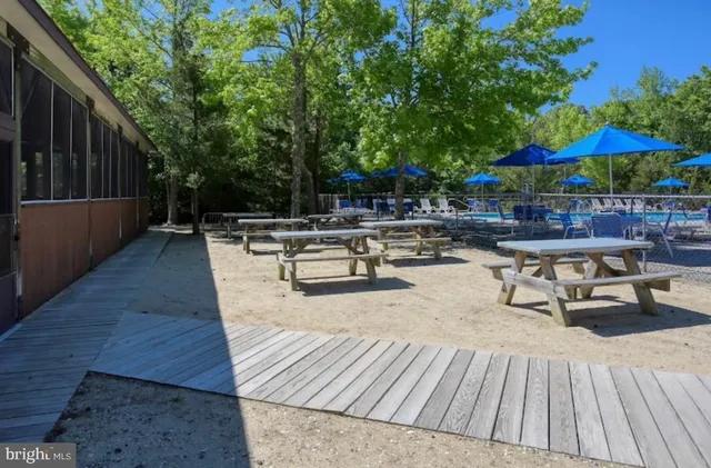 a view of patio with table and chairs under an umbrella with wooden floor