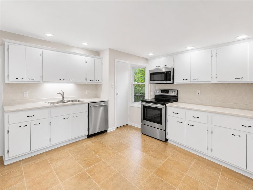 5111 Vera Cruz Road Emmaus, PA 18049 - Photo 5 of 9 A well-lit kitchen with ample white cabinetry and practical tile flooring awaits culinary creations.