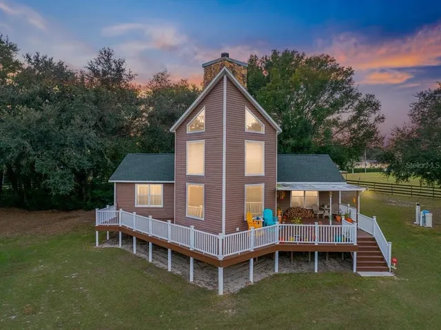 a view of a house with a wooden deck and a yard