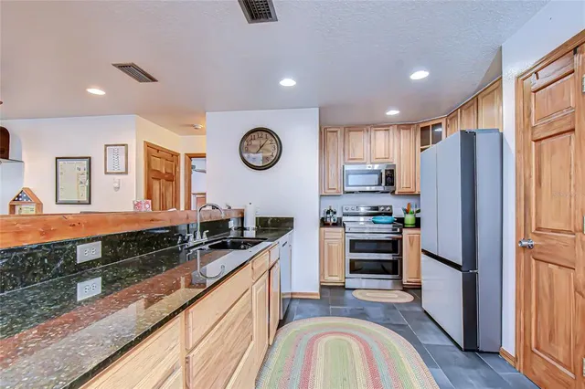 a kitchen with stainless steel appliances granite countertop a refrigerator and a stove top oven
