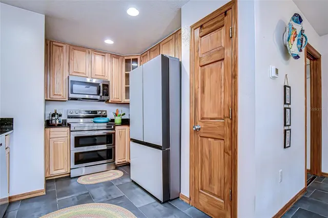 a kitchen with stainless steel appliances granite countertop a refrigerator stove and sink