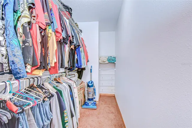 a view of walk in closet with clothes
