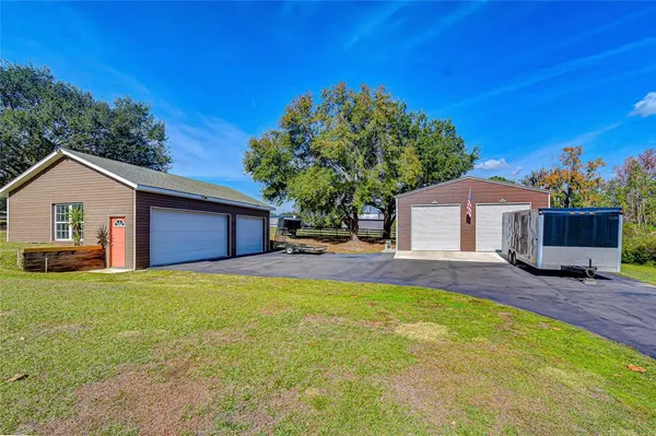 a view of a house with backyard and a tree