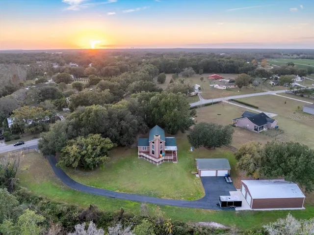 an aerial view of residential houses with outdoor space and lake view