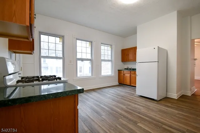 a kitchen with granite countertop wooden floors and white appliances